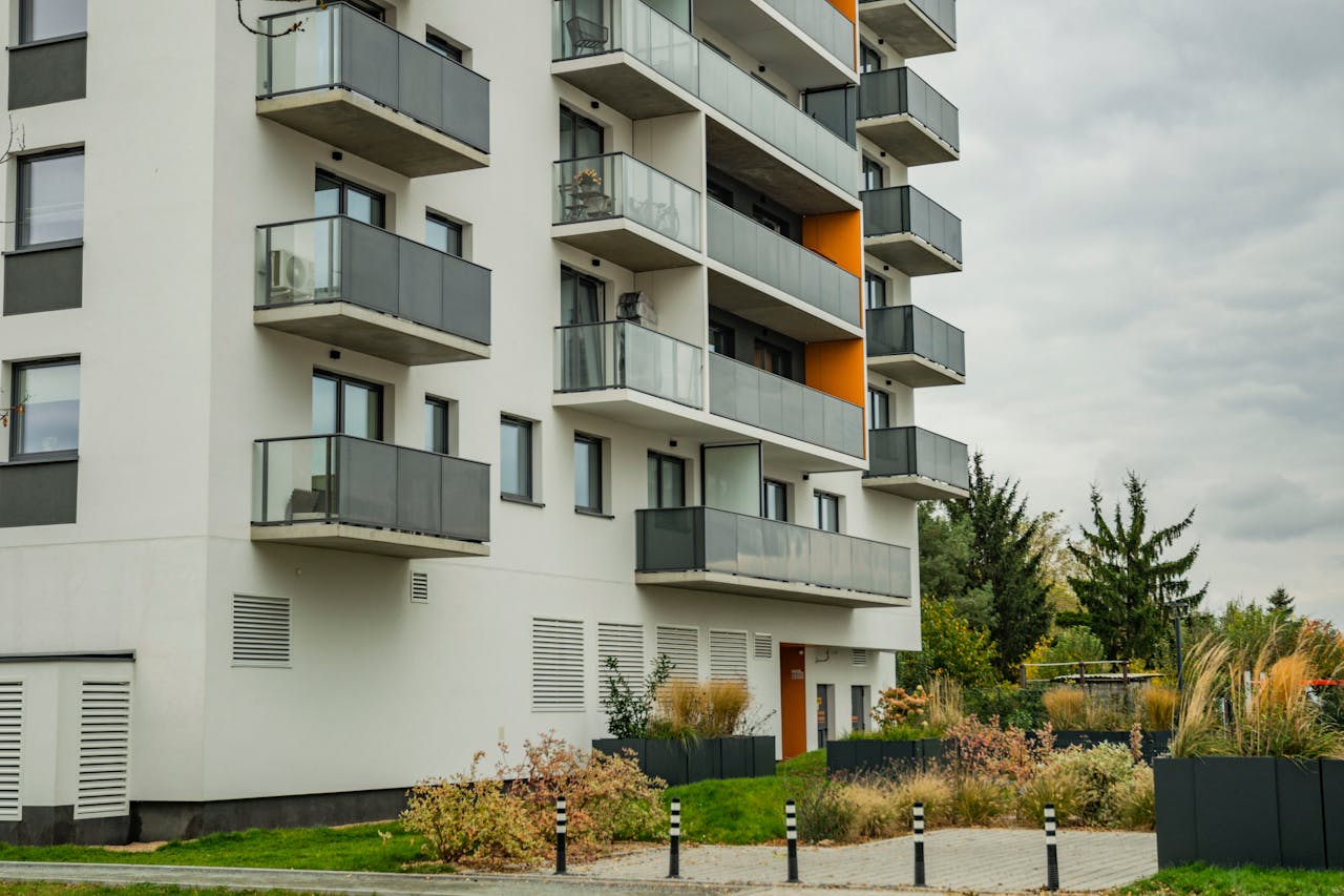 Mastering the First Impression: Your intriguing post title goes here Contemporary apartment complex featuring glass balconies and landscaped surroundings.