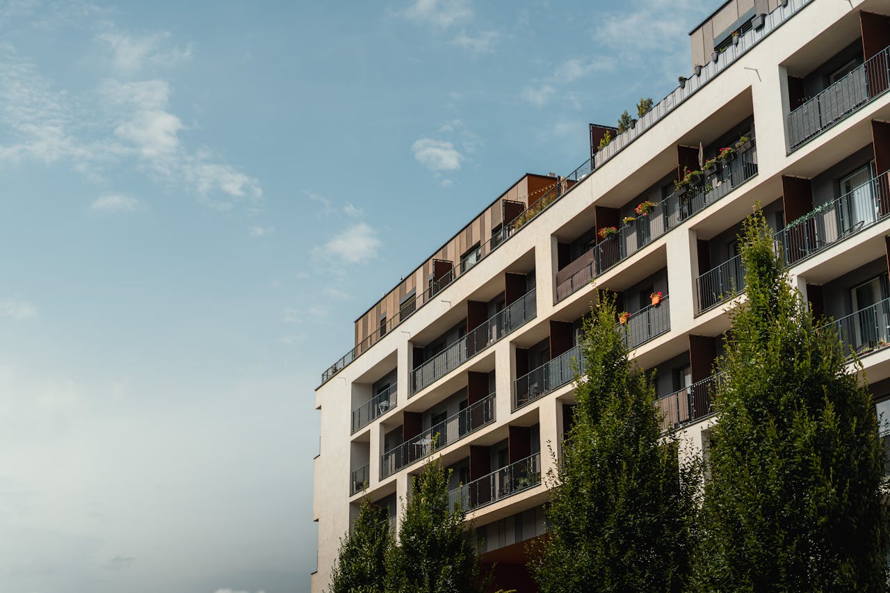 The Art of Drawing Readers In: Your attractive post title goes here Stylish modern apartment building under a clear blue sky, showcasing balconies and urban architecture.